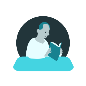 Man sitting at a table reading a book. No visible writing on the book.
